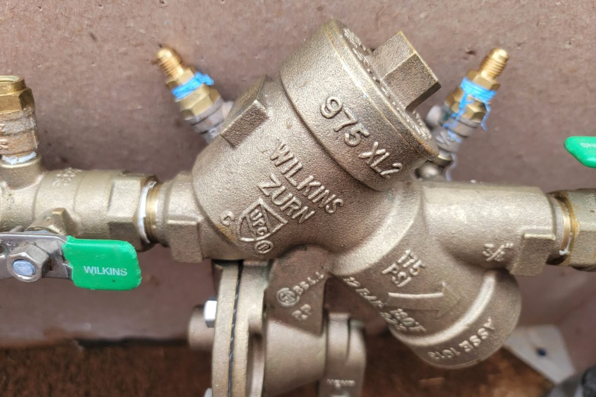 A brass backflow preventer assembly on the incoming water line