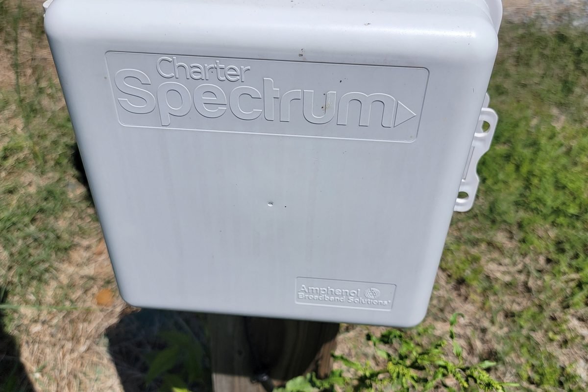 A Spectrum fiber enclosure mounted on a post at the road