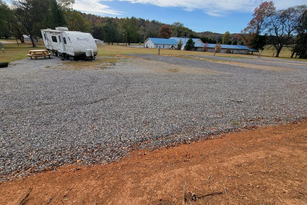 Finished level gravel pads with the park buildings and treeline behind