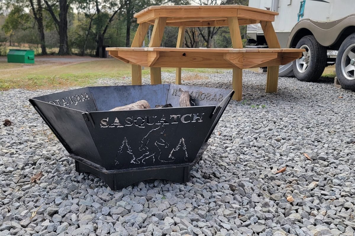 A fire pit and picnic table set up together on a finished gravel site