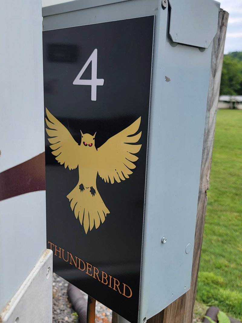 Site 4 pedestal panel, a gold Thunderbird with red eyes on black above the name Thunderbird