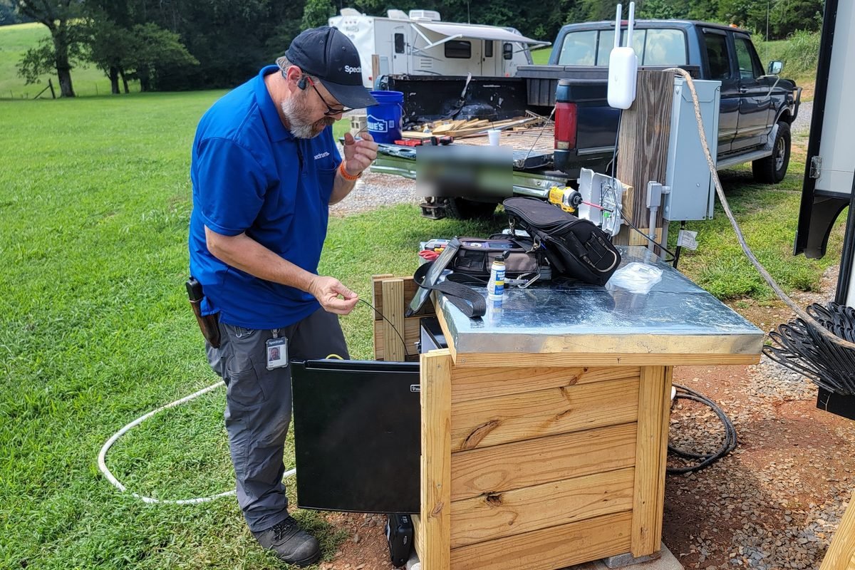 A technician terminating fiber at the park utility cabinet on install day